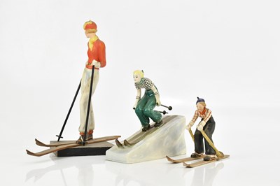 Lot 574 - Three Art Deco ceramic models of skiers,...