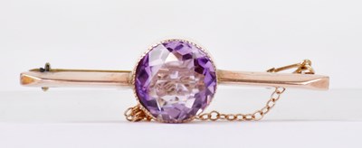 Lot 1395 - A 9ct rose gold bar brooch set with a circular...