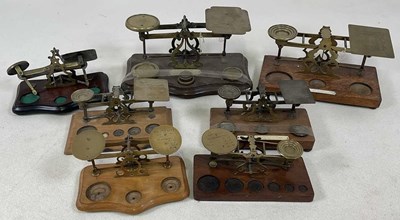 Lot 109 - Seven sets of brass wooden based postal scales.