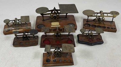 Lot 110 - Seven sets of brass wooden based postal scales.