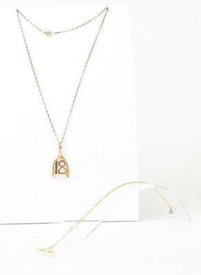 Lot 1482 - A 9ct gold '18' within a wishbone pendant on a...