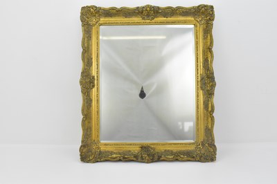 Lot 61 - A bevelled edge wall mirror in an ornate...