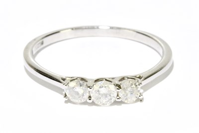 Lot 1226 - A 9ct white gold three stone diamond ring,...