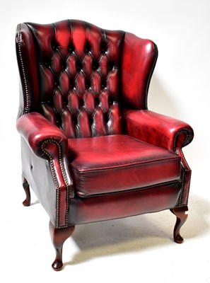 Lot 7 - A modern oxblood leather back upholstered wing-...