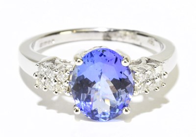 Lot 1090 - An 18ct white gold diamond and tanzanite ring,...
