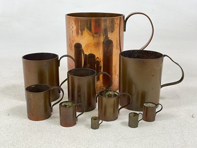 Lot 224 - A set of ten graduated copper measuring...