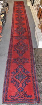 Lot 105 - A red ground runner with border and...