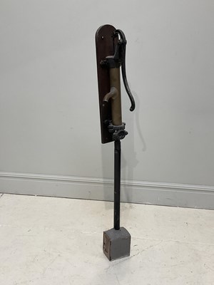 Lot 1456 - A cast iron and brass water pump, mounted oak...