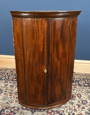 Lot 2864 - A George III mahogany bowfront corner cabinet,...