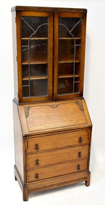 Lot 23 - A 1930s oak bureau bookcase, the glazed top...