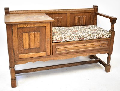 Lot 24 - An oak telephone table with linen fold detail...