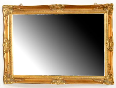 Lot 66 - A gilt wall mirror with bevelled edge glass,...