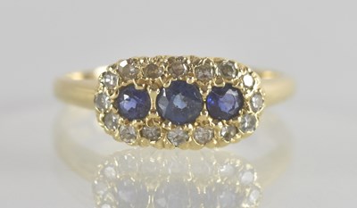 Lot 1343 - A 14K diamond and sapphire ring, the three...