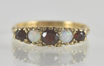 Lot 1340 - A 9ct gold opal and garnet ring, with three...