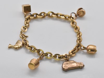 Lot 472 - A yellow metal charm bracelet set with several...
