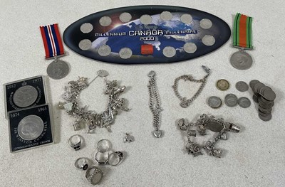 Lot 581 - A small group of coins, a silver charm...
