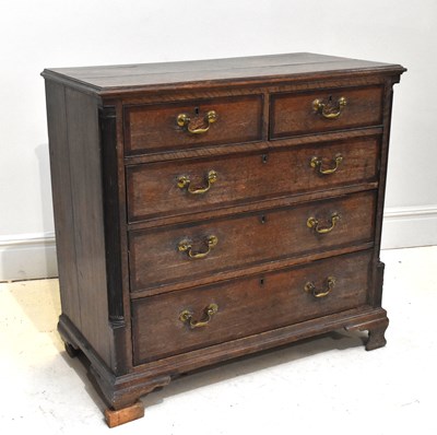 Lot 1155 - A Georgian oak chest of two short over three...