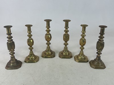 Lot 206 - Three pairs of brass candlesticks, the kings,...