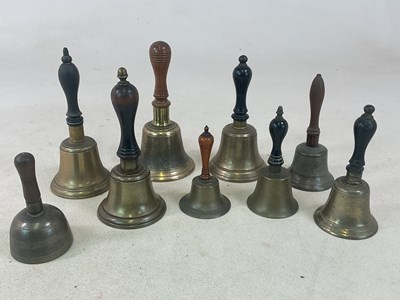 Lot 34 - Nine small brass hand bells with turned wooden...