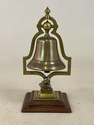 Lot 201 - A tabletop swinging bell, raised on a stepped...