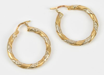 Lot 181 - A pair of yellow and white metal hoop earrings,...