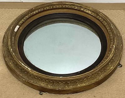 Lot 776 - A convex circular mirror with gilded surround,...