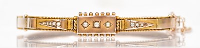 Lot 826 - An Edwardian 9ct yellow gold hinged bangle,...