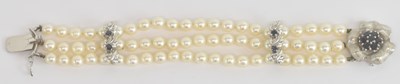 Lot 1504 - A 14ct white gold sapphire set three strand...