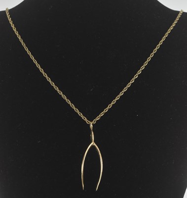 Lot 1395 - A 9ct yellow gold wishbone pendant, height...