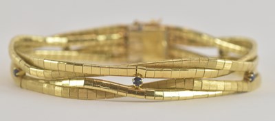 Lot 1494 - An 18ct gold multistrand gem set bracelet, the...