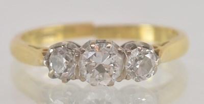 Lot 1235 - An 18ct gold three stone set diamond ring, the...