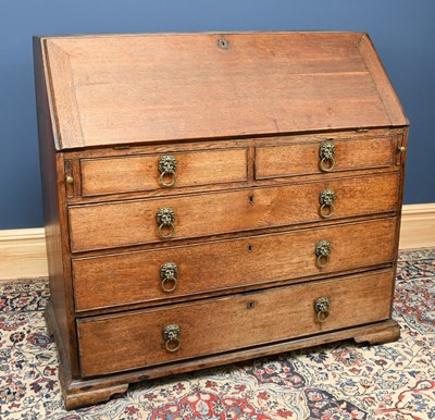 Lot 2787 - A George III oak bureau with fall enclosing a...
