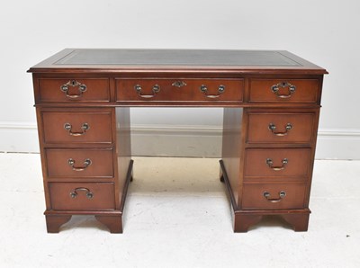 Lot 1043 - A reproduction mahogany kneehole desk with an...