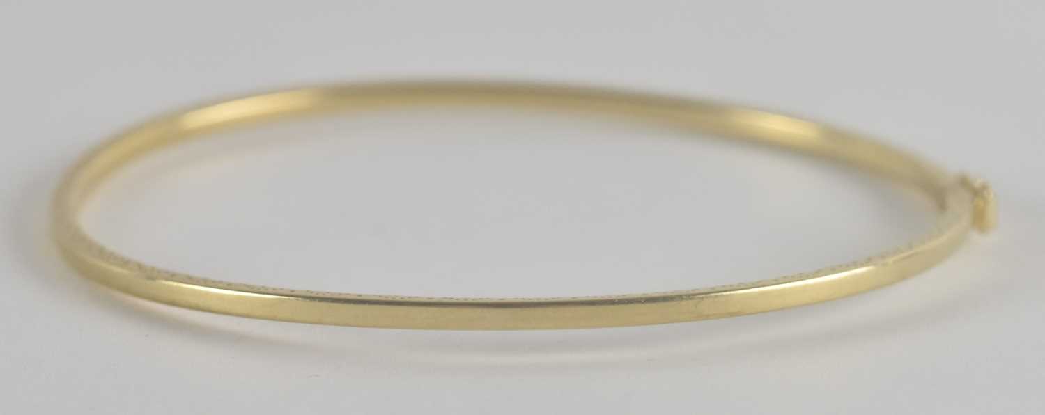 Lot 1524 - A 9ct gold hinged bracelet with safety clasp,...