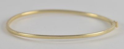 Lot 1524 - A 9ct gold hinged bracelet with safety clasp,...