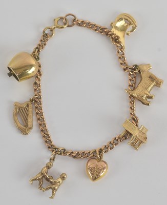 Lot 1244 - A 9ct yellow gold charm bracelet, with seven...