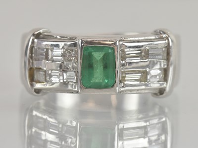 Lot 1222 - A white metal emerald and diamond set ring,...