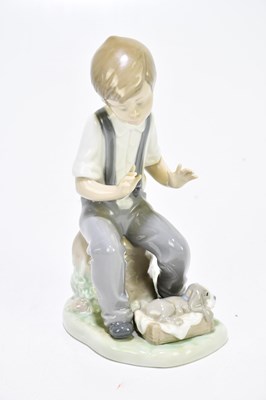 Lot 523 - NAO; three figures to include a boy playing...