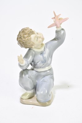 Lot 523 - NAO; three figures to include a boy playing...