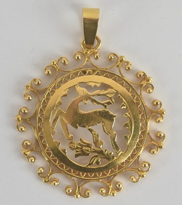 Lot 1382 - A circular yellow metal pendant of a prancing...