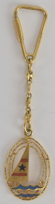 Lot 1193 - An 18ct yellow gold and enamelled keyring...