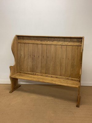 Lot 375 - A pine wingback settle, raised on simple end...