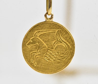 Lot 243 - A yellow metal circular pendant decorated with...
