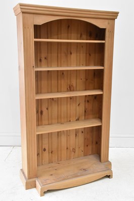 Lot 1021 - A modern pine breakfront open bookcase, with...