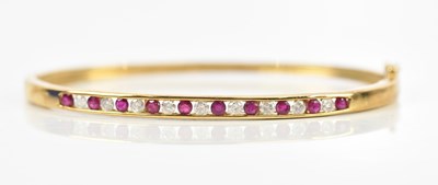 Lot 57 - A 9ct yellow gold synthetic ruby and diamond...