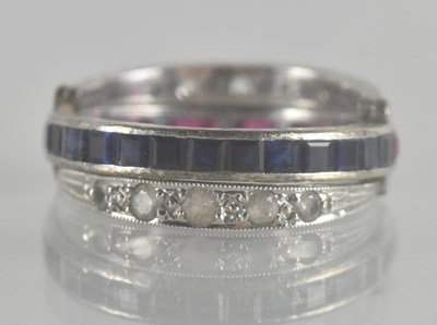 Lot 1316 - A ruby and sapphire channel set eternity ring,...
