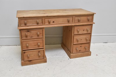 Lot 1036 - A pine twin pedestal kneehole desk, with an...