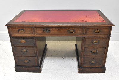 Lot 1119 - An Edwardian oak nine drawer pedestal desk,...
