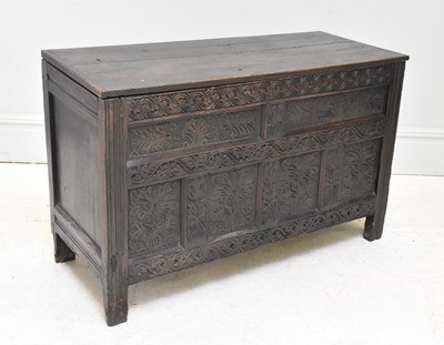 Lot 1030 - An 18th century oak coffer, with well carved...