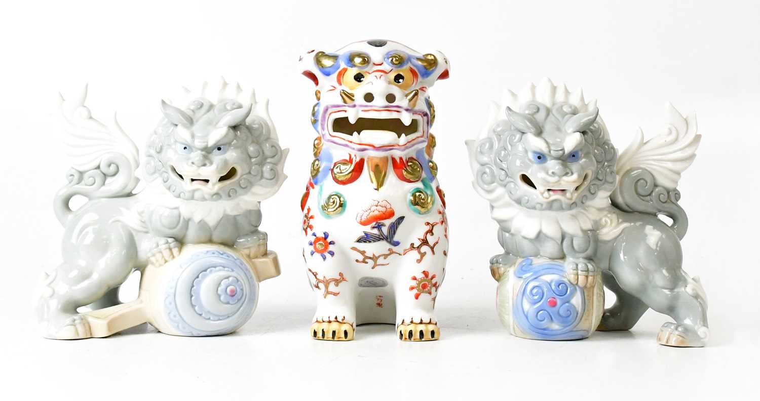 Lot 394 - YOSHIMI K; a pair of porcelain lion dogs,...